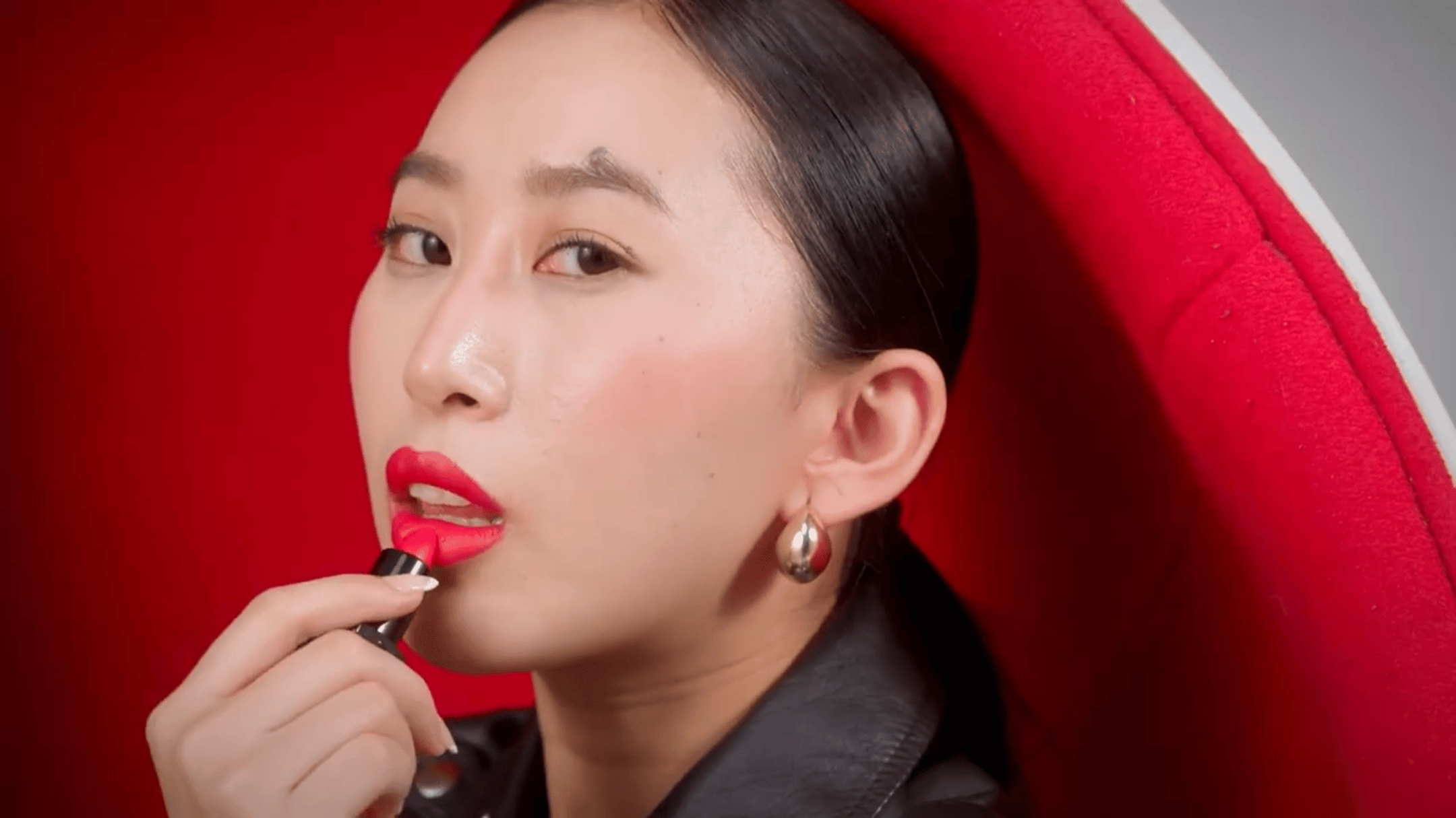 UTE lipstick portrait with model applying red shade in editorial film